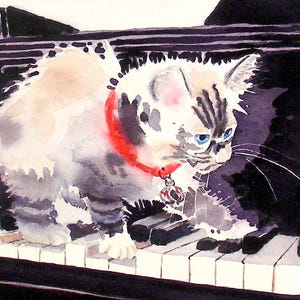 May include: A white and gray kitten with blue eyes wearing a red collar with a tag is sitting on a black piano keyboard. The kitten is looking down at the keys.