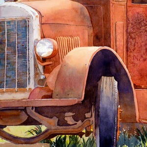 May include: A close-up of a rusty red vintage truck with a large tire and a headlight. The truck is parked in a grassy field.