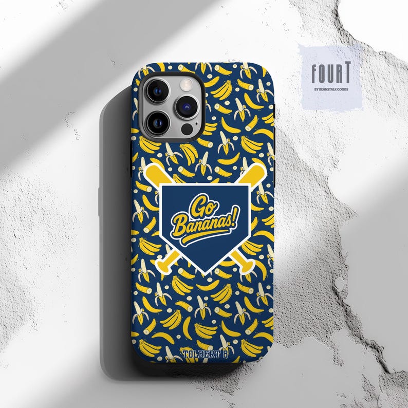 May include: A navy blue phone case with a pattern of yellow bananas and white banana peels. The case features a baseball-themed graphic with the text "Go Bananas!" in white and yellow.