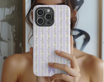 May include: A white phone case with a purple and white striped pattern and small purple flowers. The case has a cutout for the camera lens and a purple bow on the bottom.