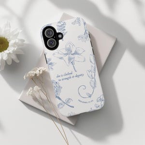 May include: White phone case with a blue floral design and the text "she is clothed in strength & dignity" and "Proverbs 31:25".