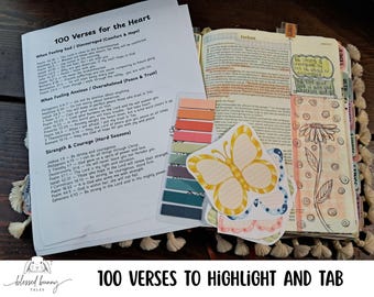 Peut inclure: Une feuille imprimée intitulée 100 Verses for the Heart, une Bible avec une fleur dessinée à la main et du texte surligné, un ensemble d'onglets adhésifs colorés et des cartes de notes en forme de papillon pour le réconfort.
