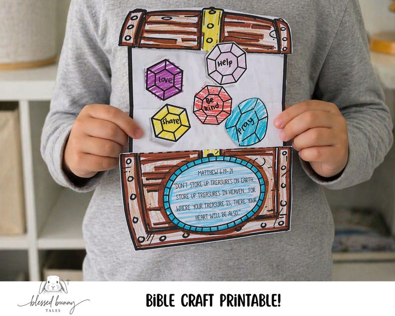 Puede incluir: Un ni&ntilde;o sostiene un cofre del tesoro de papel artesanal con recortes de gemas de colores etiquetados como "amor", "ayuda", "s&eacute; amable", "comparte" y "reza". El cofre presenta un vers&iacute;culo b&iacute;blico y las palabras "Bible Craft Printable!"