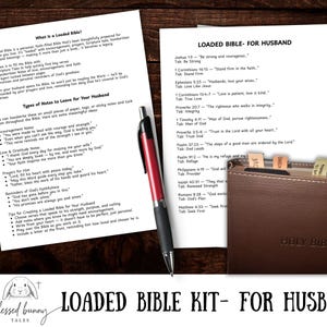 May include: A brown leather Holy Bible with a tabbed edge, accompanied by printed notes and a red and black pen. The text reads "LOADED BIBLE KIT - FOR HUSBAND". The kit includes notes and scripture references.