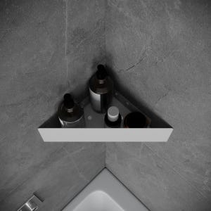 Puede incluir: Un estante de esquina blanco con tres botellas y un pequeño recipiente encima. El estante está montado en una pared de azulejos grises.