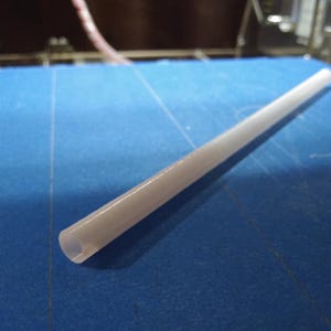 Puede incluir: Una pajita de plástico blanca sobre una superficie azul.