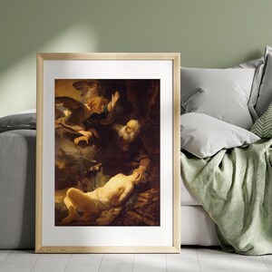 May include: A framed print of a classical painting depicting a biblical scene. An angel with outstretched wings hovers above a man with a long white beard, who is holding the head of a reclining figure. The artwork features warm, earthy tones.