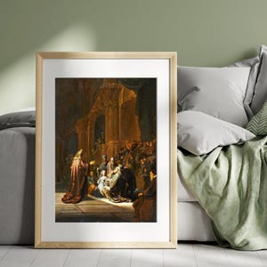May include: Framed print of a historical painting depicting a religious scene. The artwork features figures in period clothing, with a focus on a central group illuminated by a light source. The color palette is dominated by warm tones of brown, gold, and red.