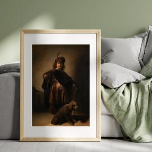 May include: Framed print of a classic painting featuring a person in period clothing with a feathered hat, a dark cloak, and a small dog. The artwork has a warm color palette with brown and gold tones, and is set against a dark background.