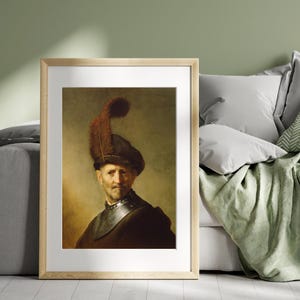 May include: Framed portrait of a man in a dark hat with a large feather and a dark outfit. The artwork is displayed in a light wood frame and is set against a neutral background. The painting has a vintage aesthetic.