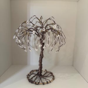 May include: A wire sculpture of a weeping willow tree with white beads for leaves and a brown wire base.