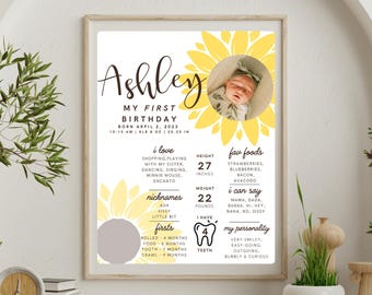 May include: A yellow sunflower-themed first birthday poster with a photo of a baby girl. The poster includes the baby's name, Ashley, birthdate, height, weight, favorite foods, firsts, and personality.