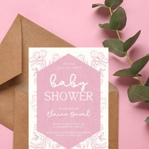 May include: A pink and white baby shower invitation with a floral border. The text reads "Please join us for a baby shower in honor of Elaine Oneal. March 13, 2022 - 12:00 PM. 123 Anywhere St, Any City. RSVP to Ashley before 25th January. Phone -123-456-7890."