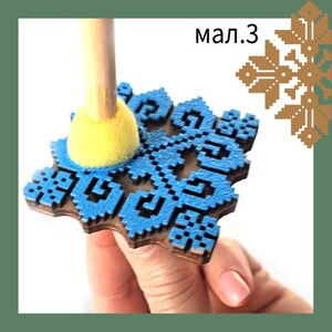 May include: A blue and brown wooden stamp with a geometric design is held by a hand. A yellow sponge applicator is positioned above the stamp. The text "мал.3" is visible in the image.