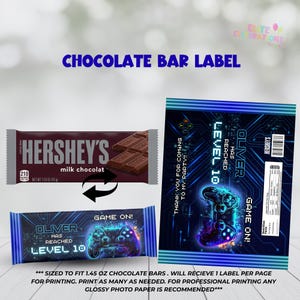 May include: Chocolate bar label with a gaming theme. The design features a Hershey's milk chocolate bar, a blue and black label with a game controller graphic, and the text "OLIVER HAS REACHED LEVEL 10".