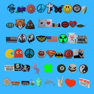 May include: A collection of colorful iron-on patches featuring various designs, including a dragon, flowers, peace signs, a cross, a butterfly, a smiley face, an eye, a skull, a tiger, poop, a playing card, a heart, the word "USA", lips, a heart with a cross, a fish, a flag, an anchor, an eagle, a video game logo, a radiation symbol, a joker card, a camper van, a ghost, a peace sign, a Muppet character, Superman, Batman, a rose, a man's face, a ninja, a skull and crossbones, a unicorn, a four-leaf clover, a pool ball, a ghost, a yin-yang symbol, a daisy, the words "HOT MESS EXPRESS", the words "STOP CHECKING OUT MY ASS", a middle finger, a green monster, a dolphin, a rock and roll hand gesture, a heart, and the words "HOT MESS EXPRESS".