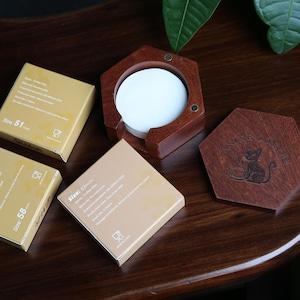 May include: A dark wooden coffee filter holder with a white filter and a matching coaster. The holder is hexagonal. Three boxes of coffee filters are visible, with sizes 51mm, 53mm, and 58mm. The coaster has a cat design.