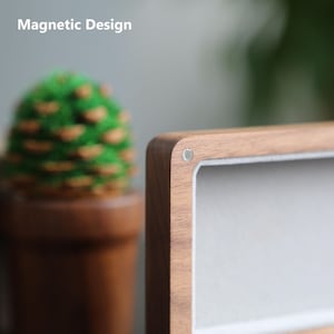 May include: Close-up of a wooden box with a magnetic closure. The box has a light brown wood finish and a white felt lining. The text "Magnetic Design" is visible in the top left corner of the image.