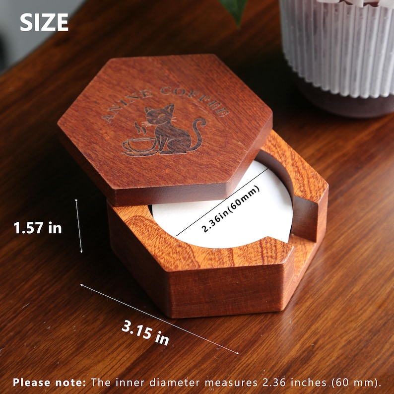 May include: A hexagonal wooden box with a hinged lid, engraved with a cat design and the words "ANIME COFFEE". The open box reveals a white interior. The dimensions are 8 cm wide, 4 cm high, and the inner diameter is 6 cm.