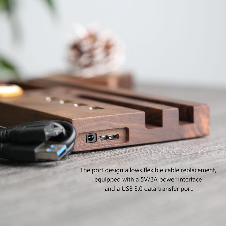 May include: A wooden charging station with two slots for phones and a USB port. The station is made of dark wood and has a sleek, modern design.
