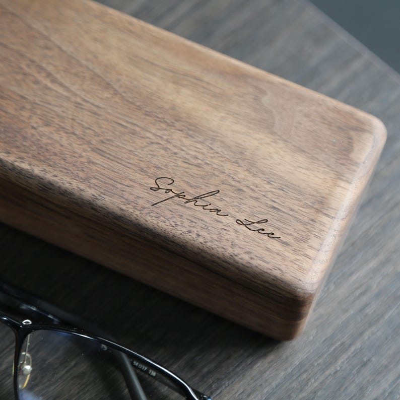 May include: A wooden box with the name "Sophia Lee" engraved on the top. The box is made of dark wood and has a smooth finish.