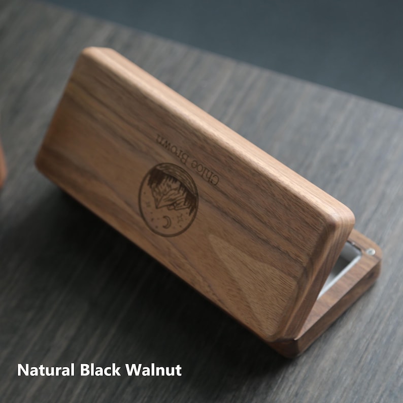 May include: A wooden box with a hinged lid, made of natural black walnut. The box has a circular design engraved on the top with the words "CHLOE BROWN".