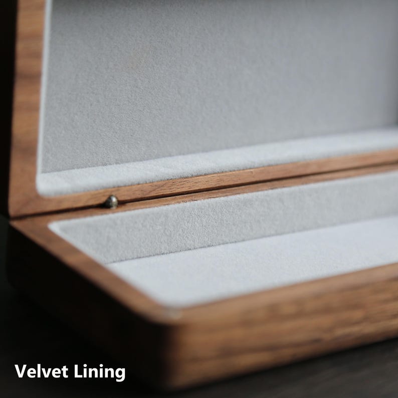 May include: A wooden box with a velvet lining. The box is open and the velvet lining is visible. The box is made of a dark wood with a natural finish.