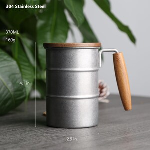 May include: A silver stainless steel mug with a wooden lid and handle. The mug is 4.1 inches tall and 2.9 inches wide. It has a capacity of 370 ml and weighs 160 grams. 304 Stainless Steel.