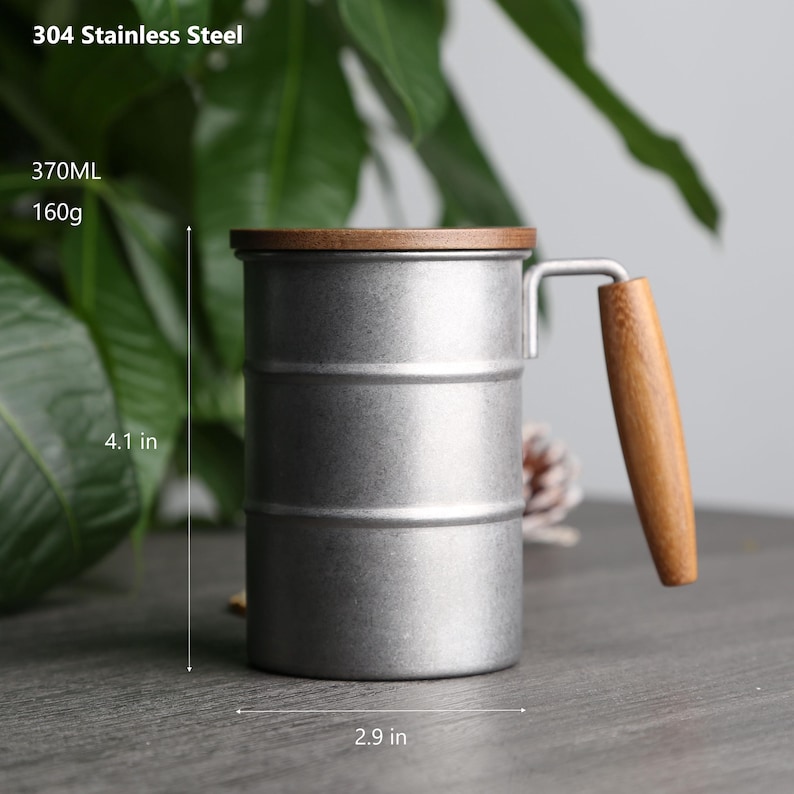 May include: A silver stainless steel mug with a wooden lid and handle. The mug is 4.1 inches tall and 2.9 inches wide. It has a capacity of 370 ml and weighs 160 grams. 304 Stainless Steel.