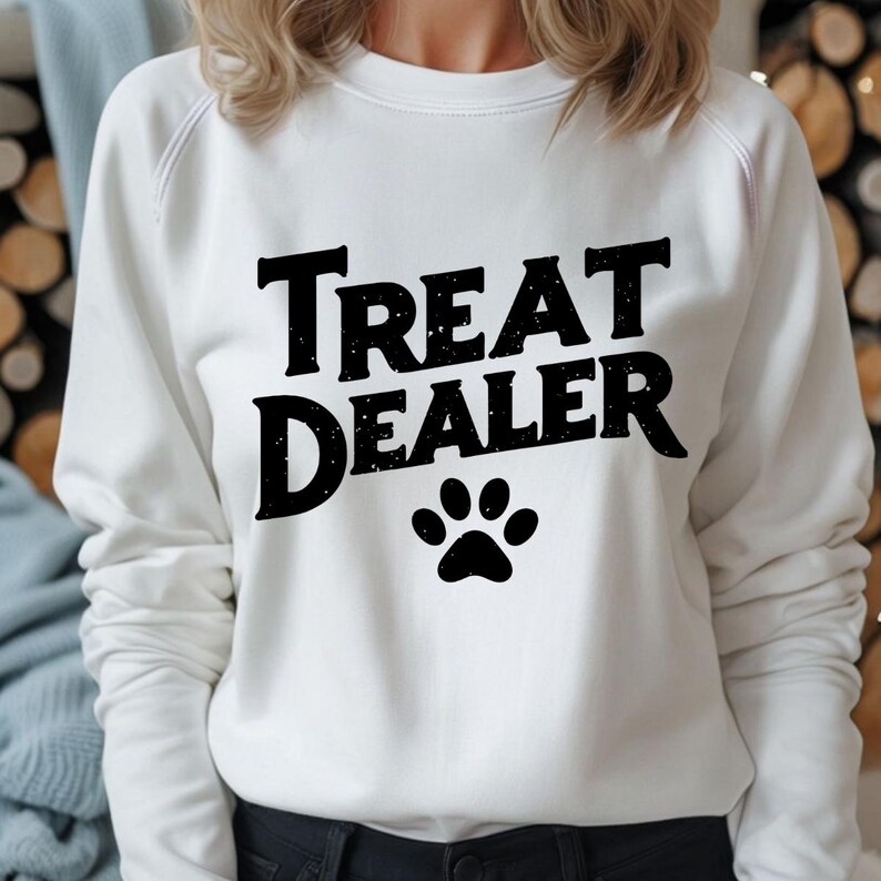May include: White sweatshirt with black text that reads "Treat Dealer" and a black paw print.