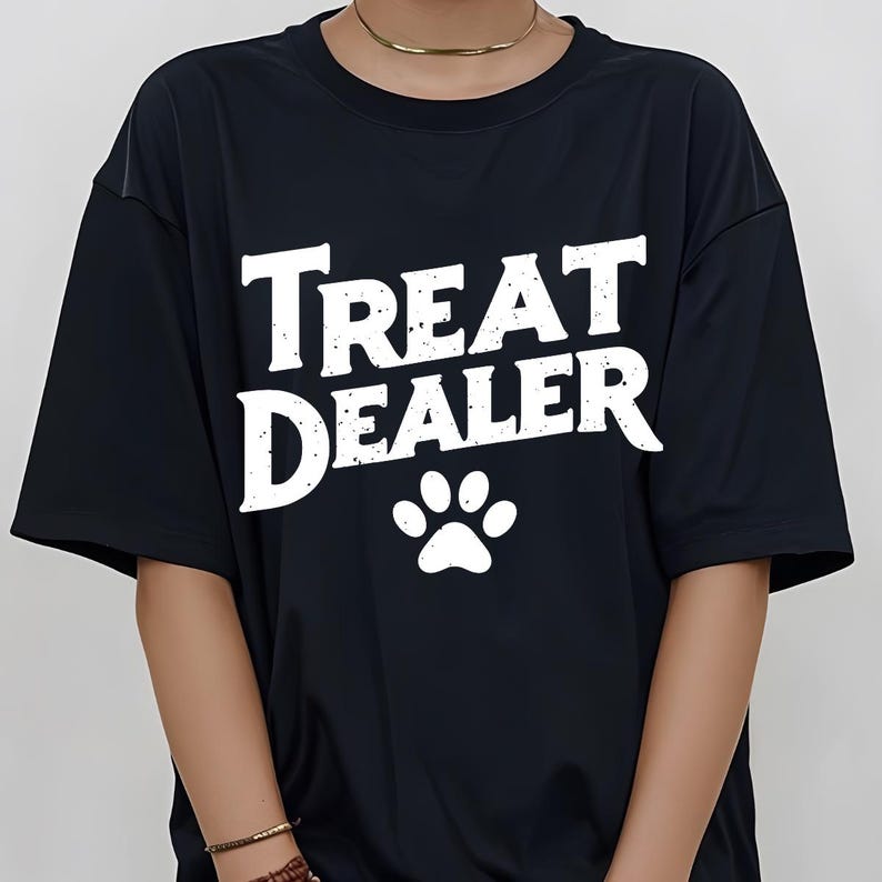 May include: Black t-shirt with white text that reads "Treat Dealer" and a white paw print.