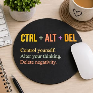 May include: A round black mouse pad featuring the text CTRL + ALT + DEL in yellow, orange, and pink. Below this, the text reads: Control yourself. Alter your thinking. Delete negativity. The text is printed in yellow, green, and orange colors.
