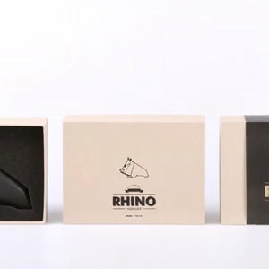 May include: Three boxes with a black rhinoceros silhouette logo. The boxes are white, beige, and black. The text on the boxes reads "Rhino" and "Toulife".