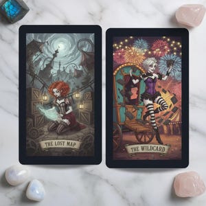 May include: Two rectangular tarot cards with black borders. The left card, titled THE LOST MAP, shows a person with red hair kneeling among crates and gears under a moonlit carnival. The right card, titled THE WILDCARD, shows a person with white hair dancing near a colourful wagon with fireworks in the background.