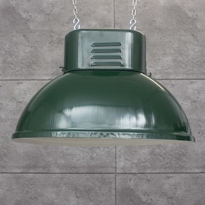 Può includere: Una lampada a sospensione industriale verde con un paralume in metallo e una catena appesa al soffitto.
