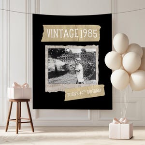 May include: Black backdrop with a vintage photo of a person watering a garden. The text "VINTAGE 1985" is above the photo, and "JOHN'S 40TH BIRTHDAY" is below. White balloons and a gift box are on the right.