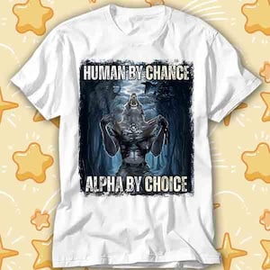 Puede incluir: Camiseta blanca con un gráfico de un hombre lobo en un bosque oscuro. El texto "HUMAN BY CHANCE" está encima de la imagen y "ALPHA BY CHOICE" debajo. El hombre lobo tiene una constitución musculosa y está aullando.