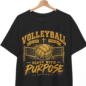 Op de afbeelding: Een zwart t-shirt met korte mouwen en een gele grafische print van een volleybal en een net. De tekst luidt VOLLEYBALL, DIG DEEP, TRUST GOD, SERVE WITH PURPOSE en ISAIAH 40:31. Het ontwerp heeft een verweerde, getextureerde uitstraling.