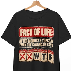 Może przedstawiać: Czarny t-shirt z krótkim rękawem z grafiką zawierającą napis FACT OF LIFE: AFTER MONDAY & TUESDAY EVEN THE CALENDAR SAYS. Poniżej znajduje się pięć kartek z kalendarza od poniedziałku do piątku, z czerwonymi krzyżykami na pierwszych dwóch.