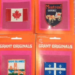 May include: Four vintage embroidered patches on orange and pink packaging. Patches include a Canadian flag, a Montreal Quebec crest, a 1000 Islands scene, and a Quebec flag. The packaging reads "GRANT ORIGINALS" and "MADE IN CANADA".