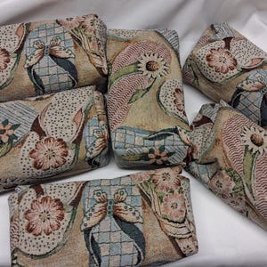 May include: A collection of six rectangular fabric pouches featuring a woven tapestry design. The pattern displays a repeating motif of butterflies, stylized flowers, and geometric shapes in muted tones of beige, blue, pink, and brown.