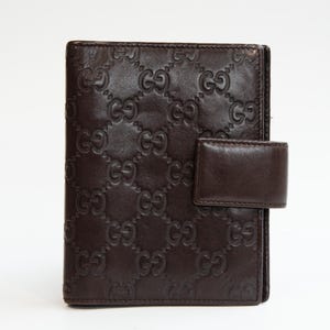 Funda para agenda Gucci en piel marrón con estampado GG Web Guccissima en relieve.