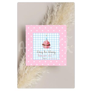 May include: A pink and white polka dot birthday card with a cupcake illustration. The cupcake has pink frosting and a lit candle. The card has text in a script font that reads "Deig ha bloag laeuen dit!" and "Joyeux anniversaire!"
