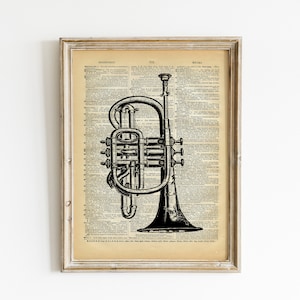 May include: A black and white illustration of a trumpet on a vintage dictionary page. The page is framed in a light wood frame.