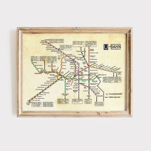 Puede incluir: Un mapa de estilo vintage del sistema de metro de Berlín, el U-Bahn. El mapa presenta una red de líneas de diferentes colores, con los nombres de las estaciones y los números etiquetados en alemán. El mapa está enmarcado en un marco de madera claro.