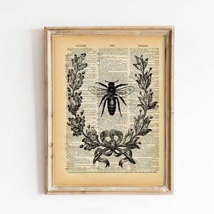 May include: Black and white illustration of a bee surrounded by a wreath of leaves and a bow on a vintage dictionary page. The text on the page reads "ENCYCLOPEDIA 1922 SOCIABLE".