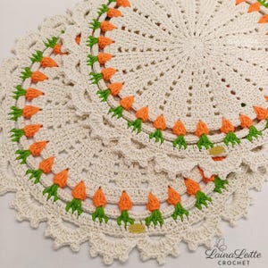 Peut inclure: Nappes crochetées de couleur crème avec un motif de carottes. Chaque nappe présente un motif circulaire avec des accents de carottes orange et des feuilles vertes sur les bords. Les nappes sont faites à la main et ont une bordure décorative festonnée.