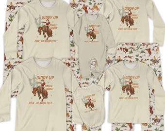 Könnte beinhalten: Eine Kollektion beiger Schlafanzüge mit Cowboy-Motiv. Die Sets umfassen langärmlige Shirts, Strampler und Schlafanzughosen. Jedes Shirt zeigt einen Cowboy auf einem Pferd mit dem Text "Giddy Up, Jingle Horse, Pick Up Your Feet."