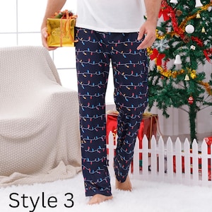 May include: Navy blue pajama pants with a repeating pattern of colorful Christmas lights. The pants are part of a holiday-themed collection. The text "Style 3" is visible at the bottom of the image.