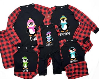 May include: Matching family pajama sets featuring black tops with penguin graphics and red plaid sleeves and pants. Each top has a different text label: "Dad", "Mommy", "Sister", "Brother", and "Custom".